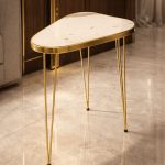 Gold hairpin side table styled with coffee and decor accents